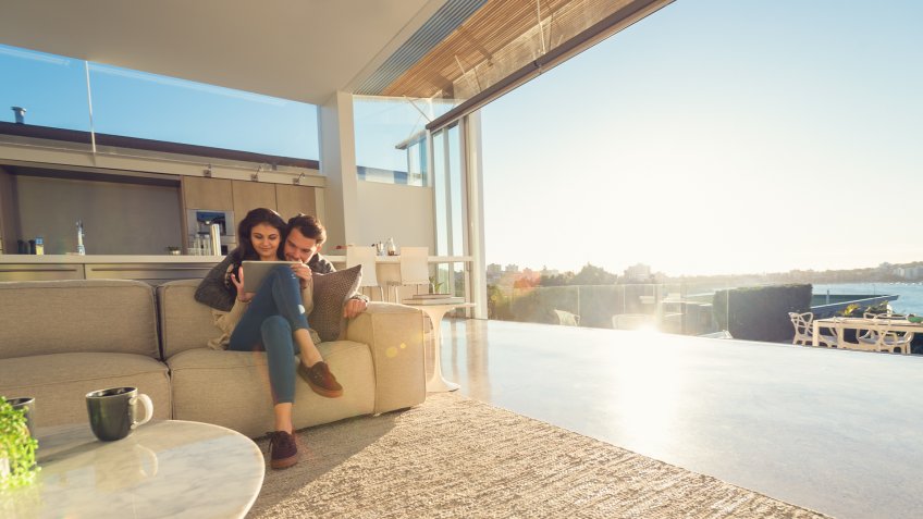 Couple at home using a digital tablet.