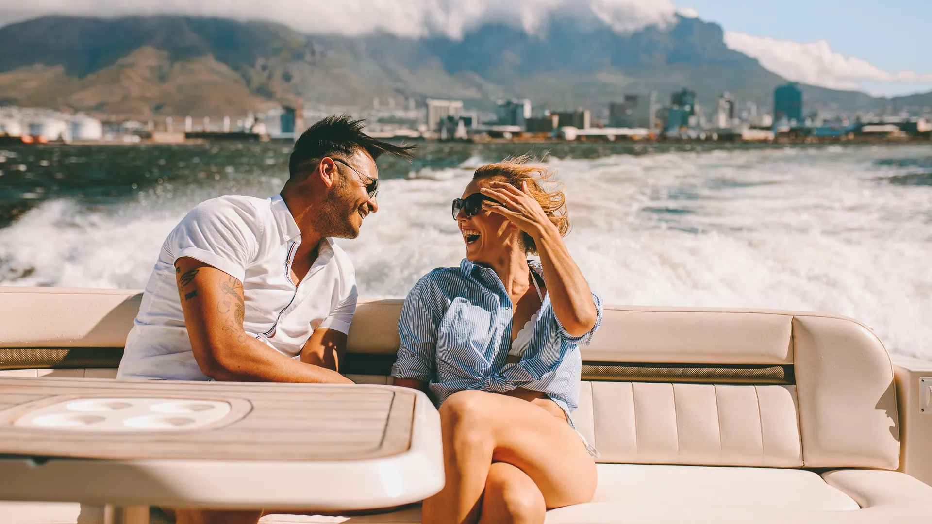 一对快乐的年轻夫妇坐在船上。