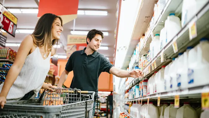 A happy young couple shop for produce and basic foods staples at their local grocery store in Los Angeles, California.