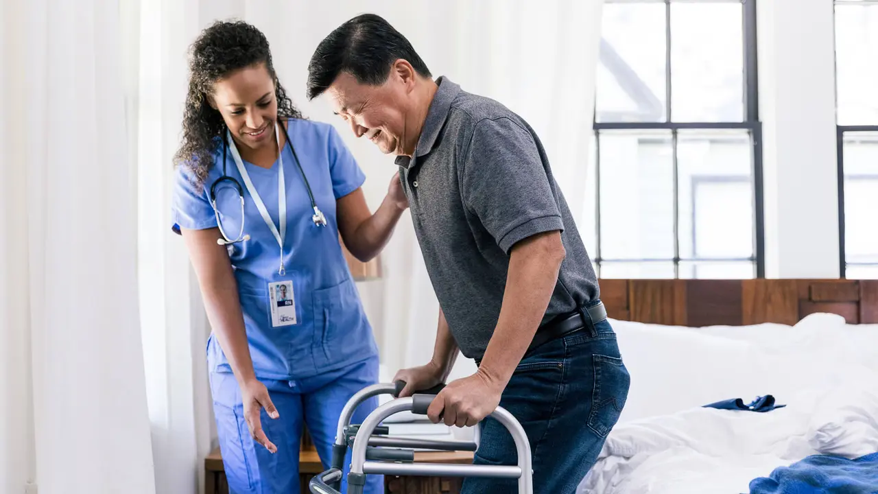 Senior man uses a walker to help him get out off bed.