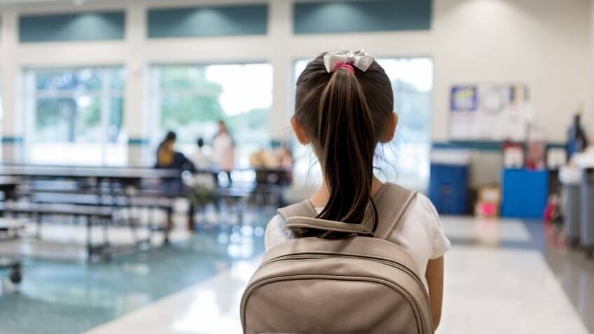 Elementary schoolgirl enters the school cafeteria.