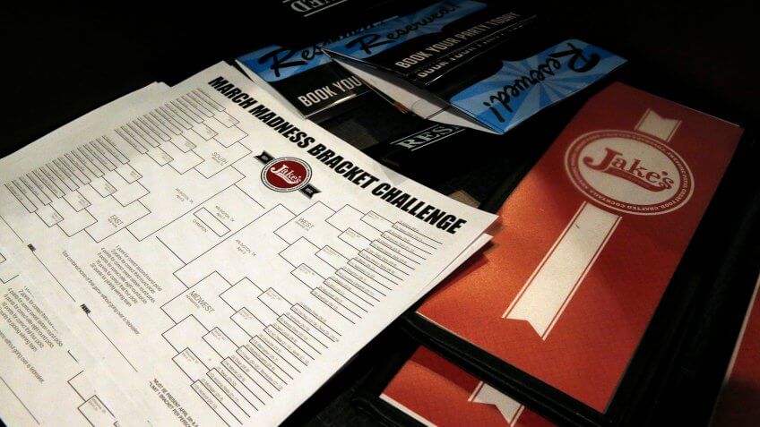 A stack of blank NCAA brackets sits with menus, available to patrons at Jake's sports bar, in Denver, .
