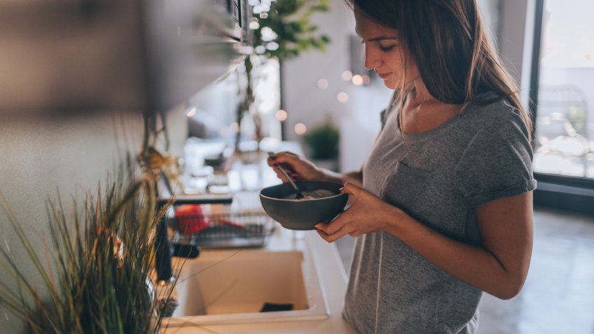 Young woman having healthy breakfast in the morning in her apartment.