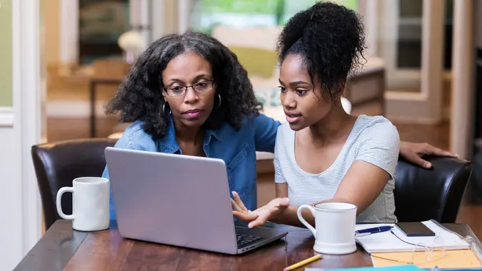 A mature woman helps her daughter study for an exam.