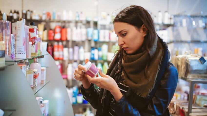 Vintage toned portrait of a young beautiful brunette woman in London cosmetics shop.