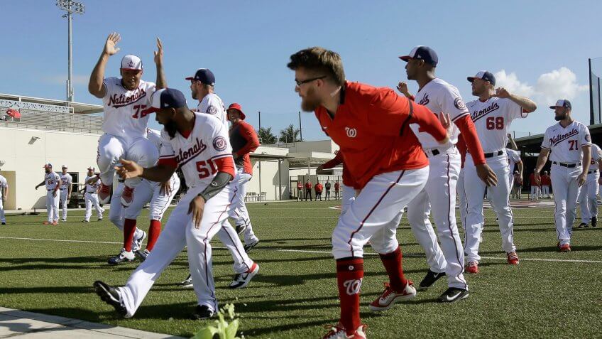 Washington Nationals pitcher Sean Doolittle smashes a cabbage on a sidewalk while teammates cheer as part of a team building exercise and in recognition of National Cabbage Day during spring training baseball practice, in West Palm Beach, FlaNationals Spring Baseball, West Palm Beach, USA - 17 Feb 2020.