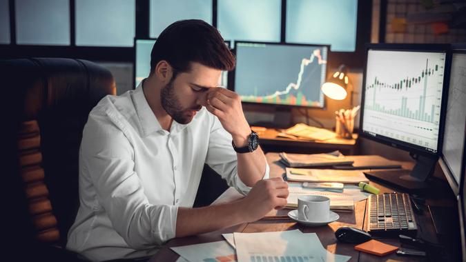 Depressed frustrated trader tired of overwork or stressed by bankruptcy, sad and shocked investor desperate because of financial crisis or money loss, upset businessman with headache massaging nose bridge.