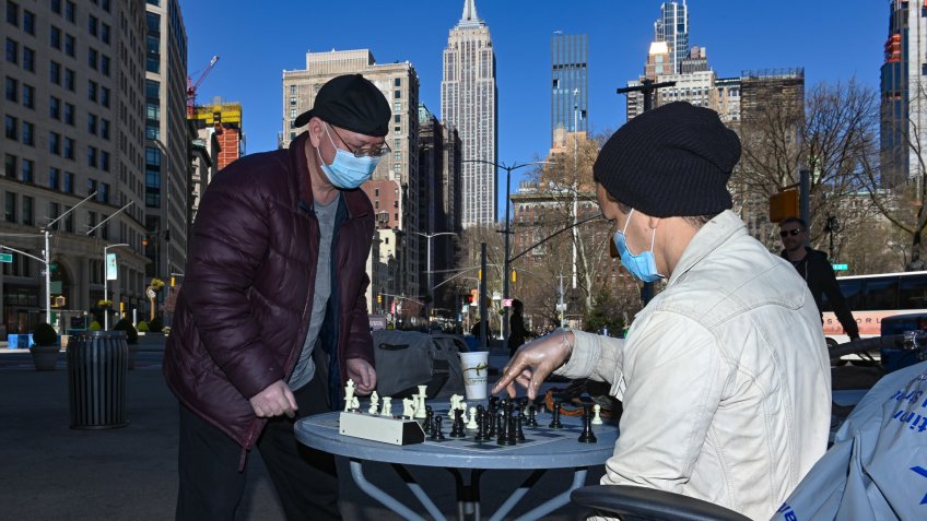 Two men, who identified themselves as "Big Jay' and "The Genius", wear protective masks and gloves while playing a game of chess in the Flat Iron District of New York.