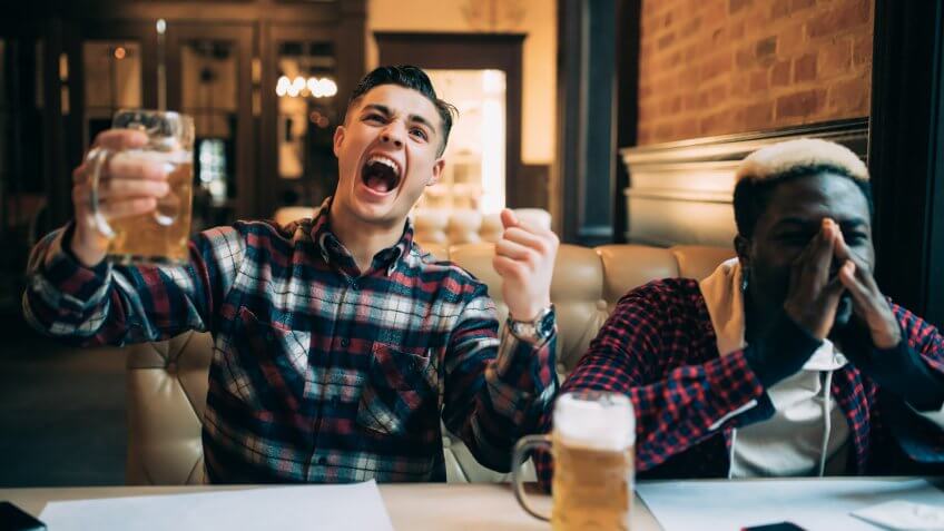 two men watch sports at bar