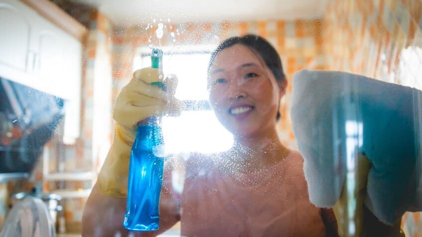 Woman cleaning glass window.