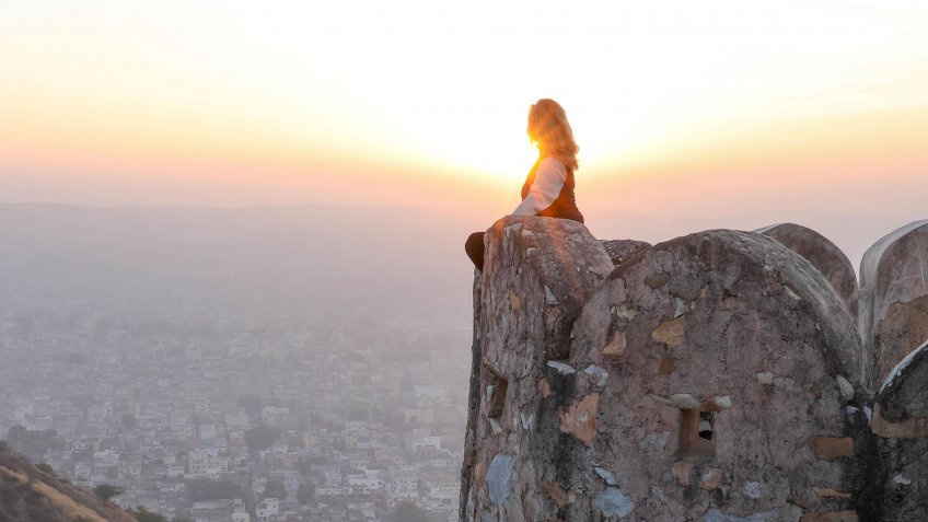 woman on cliff at sunset.