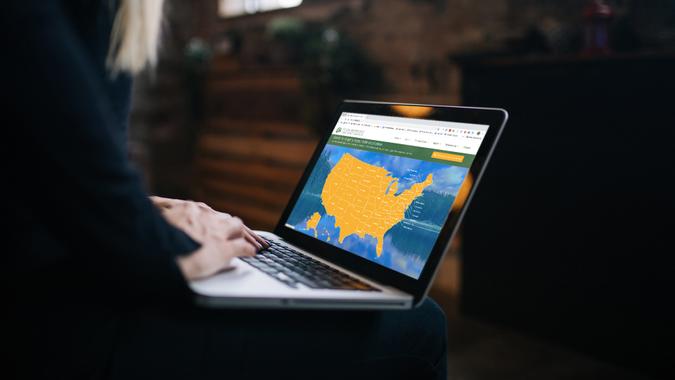 Young woman using laptop with blank screen.