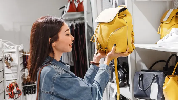 woman in shop choosing leather bags and backpacks, fashion accessories and shopping concept.
