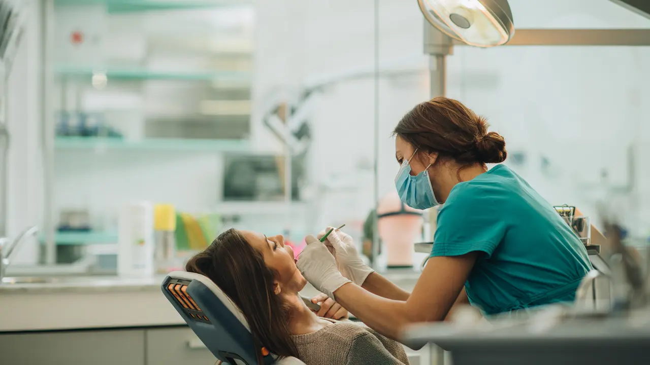 Female dentist examining young woman's teeth.