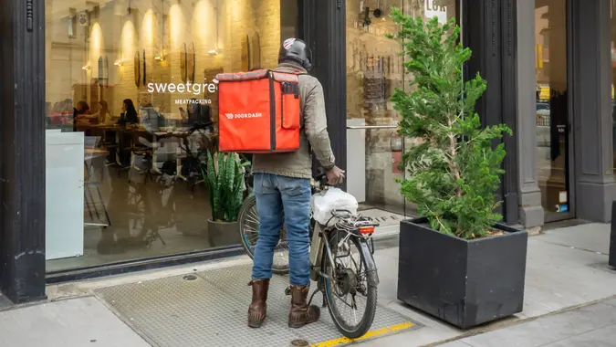 New York NY/USA-October 28, 2018 A DoorDash delivery person outside of a branch of the Sweetgreen restaurant chain in the Meatpacking District in New York.