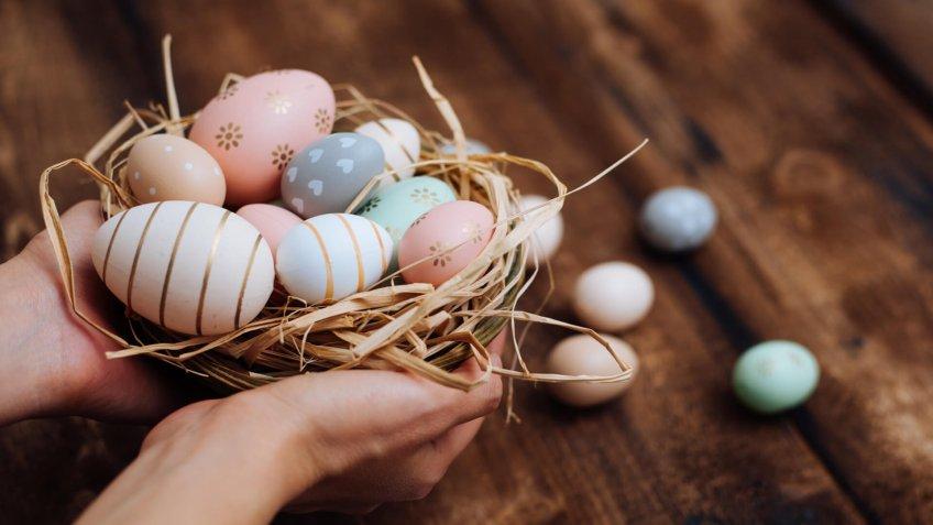 Hands holding stylish easter eggs.