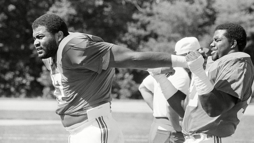Mandatory Credit: Photo by Mike Kullen/AP/Shutterstock (6559220a)New England Patriots' Kenneth Sims of the University of Texas, the top pick in the National Football League draft, warms up, with an assist from Charles Cook, as the Patriots started training camp with the first workout for rookies and selected veterans at Bryant College in Smithfield, R.