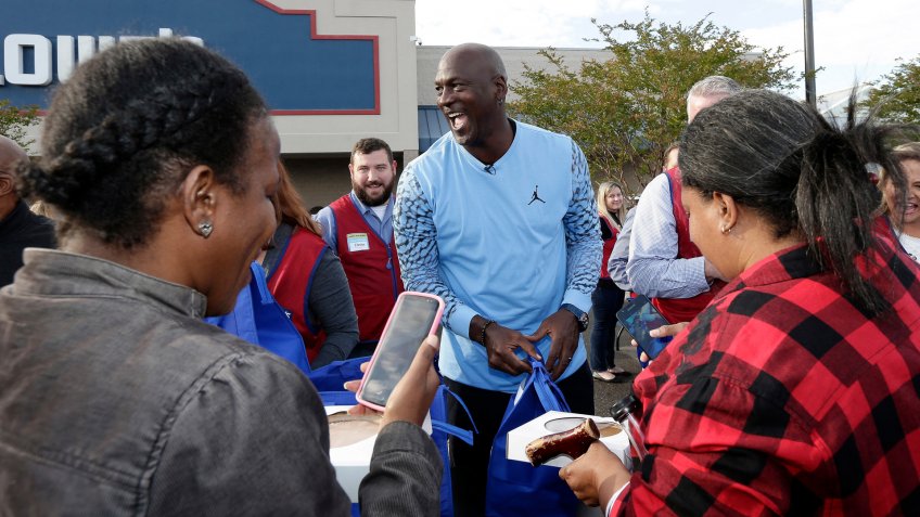 Charlotte Hornets owner Michael Jordan greets people and hands out food for Thanksgiving to members of the community in Wilmington, N.