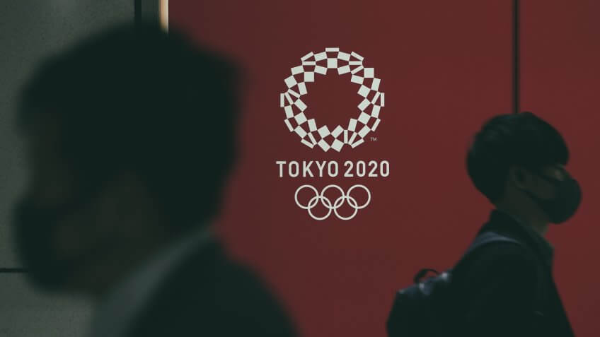 Mandatory Credit: Photo by KIMIMASA MAYAMA/EPA-EFE/Shutterstock (10591296h)Pedestrians wearing masks walk past the emblem of the Tokyo Olympic Games in Tokyo, Japan, 23 March 2020.