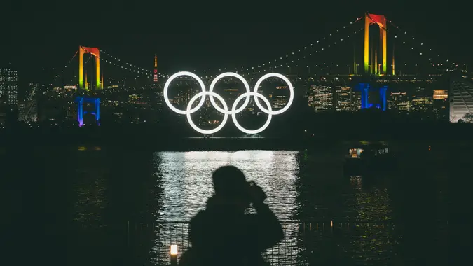 Mandatory Credit: Photo by Jae C Hong/AP/Shutterstock (10578454a)A photographer takes pictures of the illuminated Olympic rings in front of the Rainbow Bridge, in the Odaiba district of Tokyo.