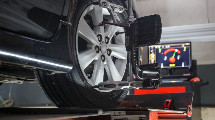 Car on stand with sensors on wheels for wheels alignment camber check in workshop of Service station.