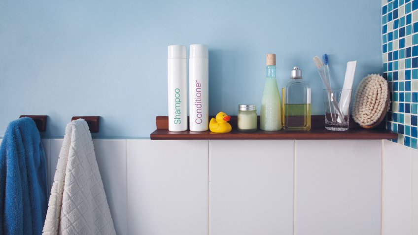 Blue wall and a shelf in the bathroom with hygiene accessories.
