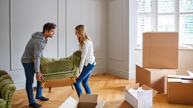 Shot of a happy young couple moving furniture in their new house.
