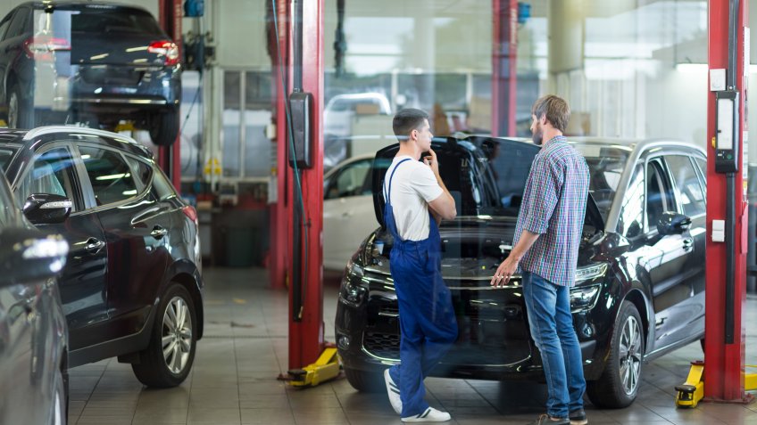 Man having problems with car visiting repair shop.