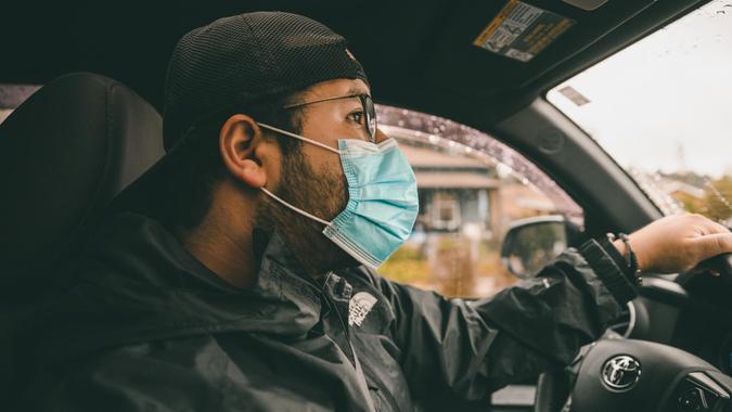 Los Angeles, Ca/USA - April 5, 2020: A millennial wearing a medical face mask while driving.