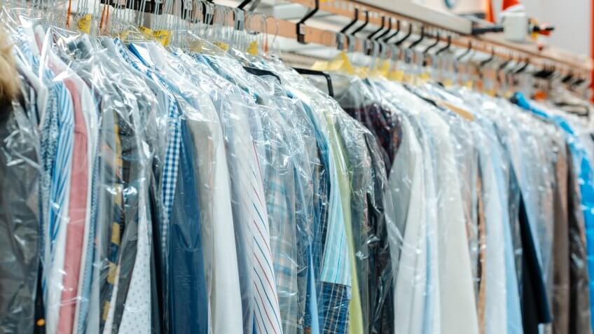 Carousel of clothing waiting for pick-up by their owners in dry cleaning shop.