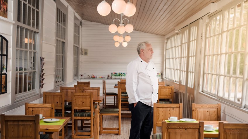 Restaurant owner standing in his empty restaurant.