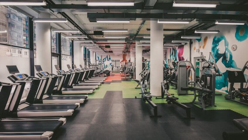 Large group of exercise machines in an empty gym.