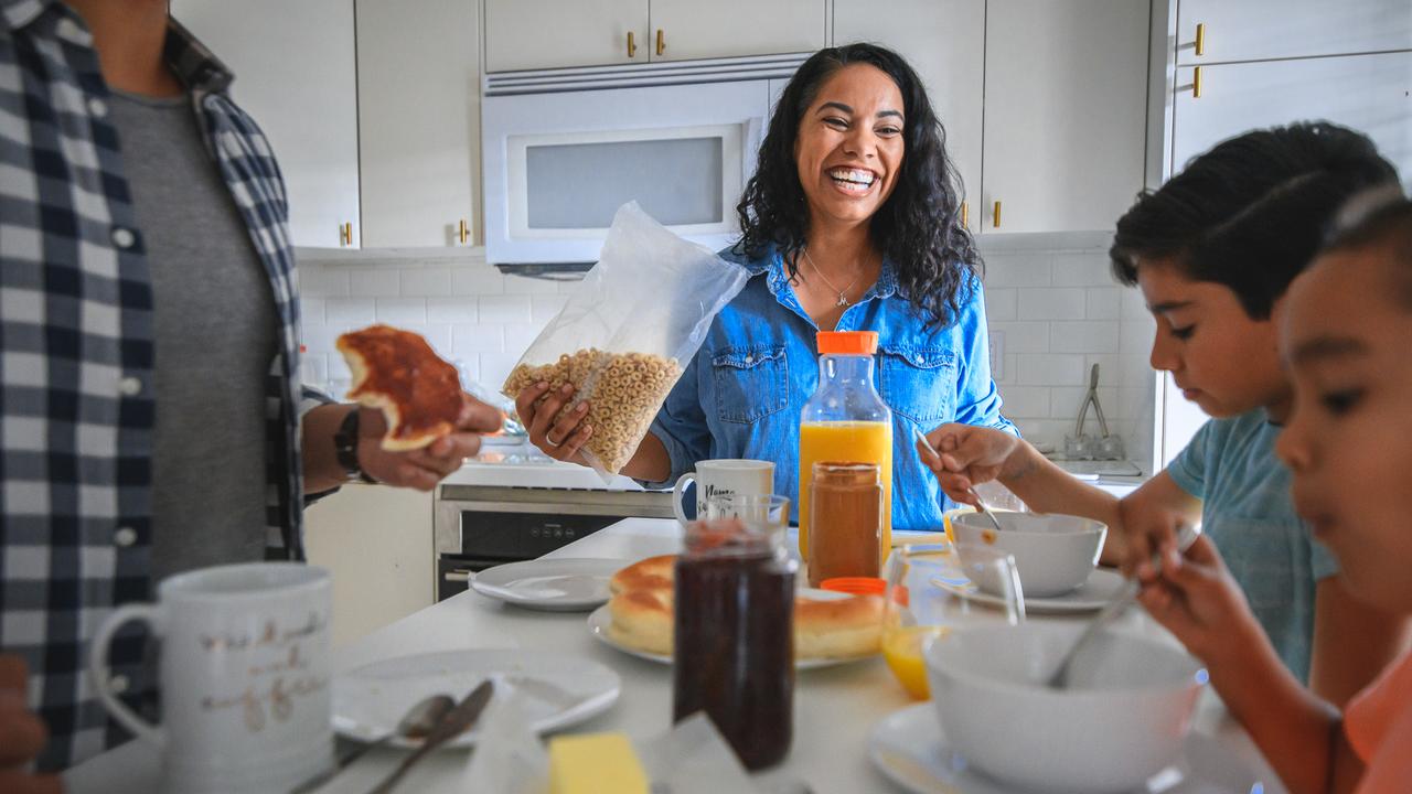 Smiling mid adult woman having breakfast with family.