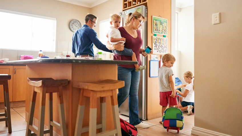Shot of couple getting their children ready for the school.