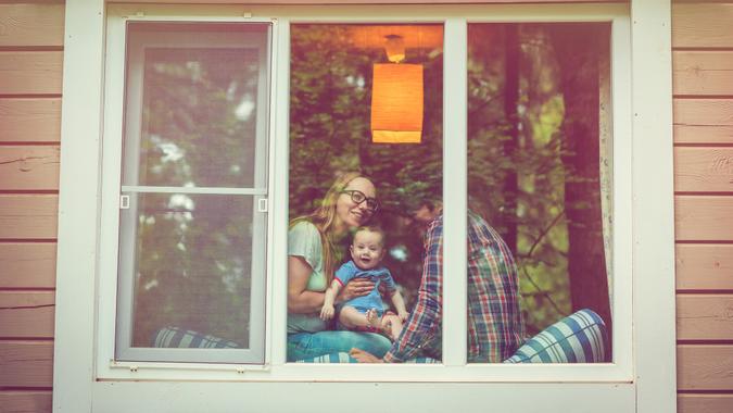 Parents with their baby through a window.