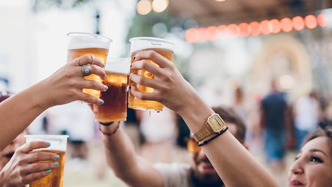 Group of people on a music festival Group of four friends toasting with beer on a music festival.