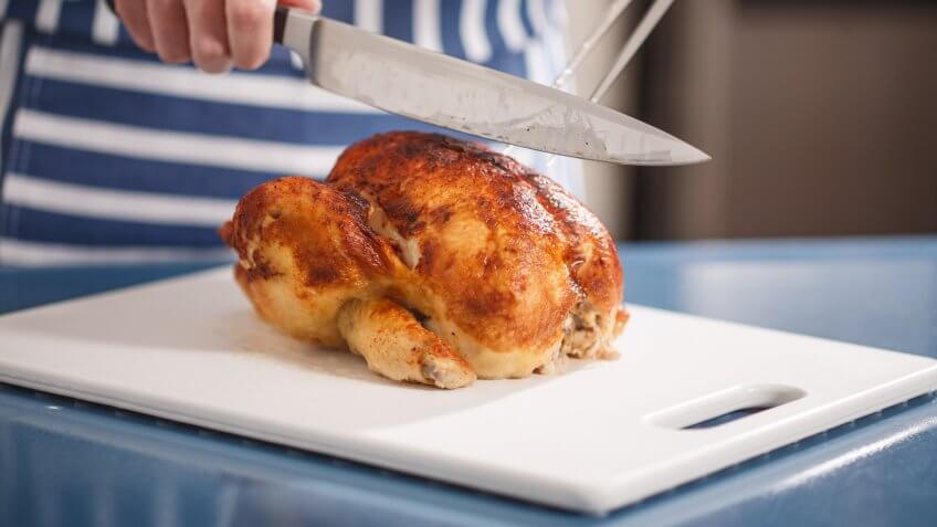 Slicing Chicken on cutting board.