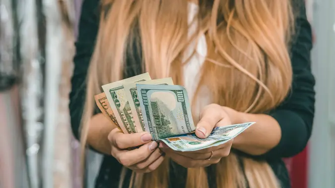 Female hands with dollar banknotes close up.