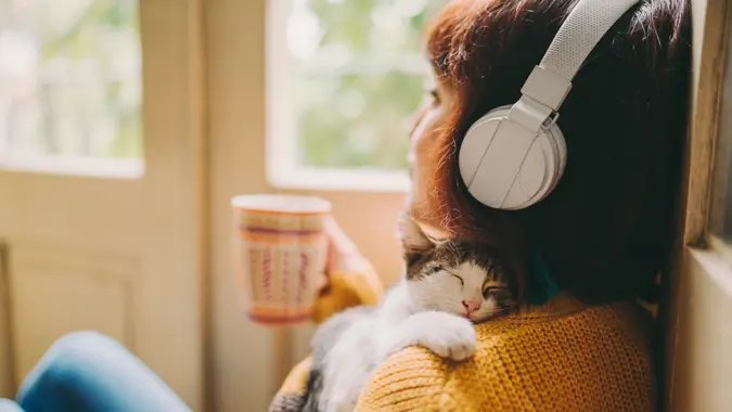 Woman at home listening to music and drinking coffee.