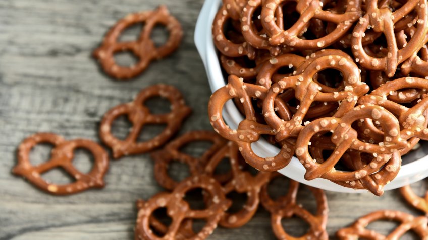 Hard Pretzels or Salted pretzels snack for party in white bowl on wooden floor.