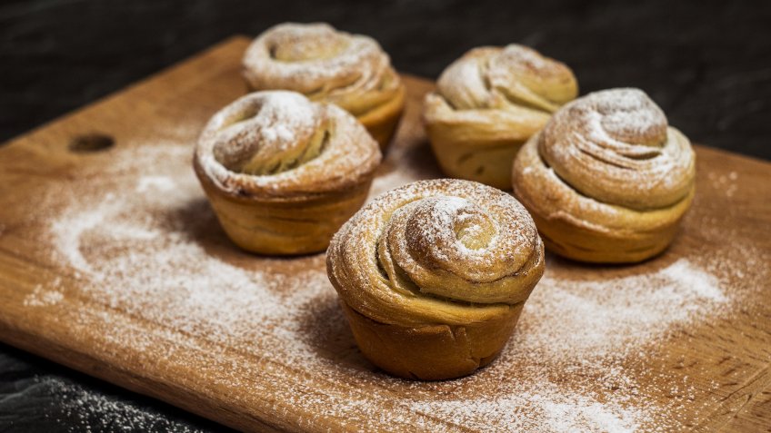 Homemade pastries cruffins, muffin with sugar powder, on wooden desk and dark background, selective focuse.