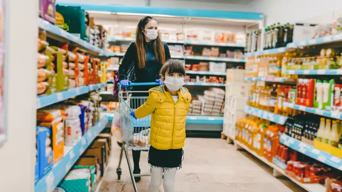 mother and daughter wearing masks and gloves and shopping.