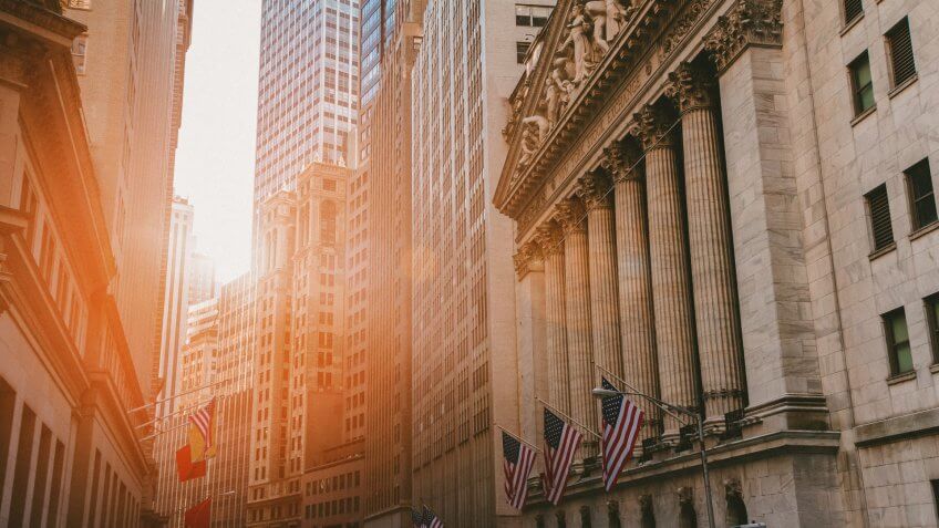 Sunlight shines on the historic buildings of the financial district in lower Manhattan, New York City near Wall Street.