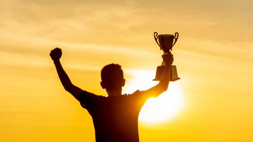 Winner win holding golden champion trophy cup prize.