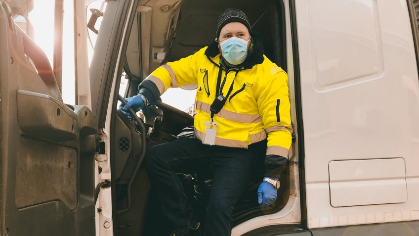 young transporter on the truck with face mask and protective gloves for Coronavirus.