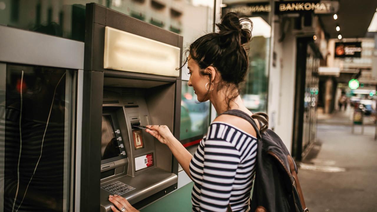 Woman using ATM machine.