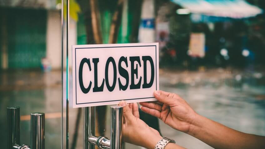 Hands of hairstylist closing barbershop.
