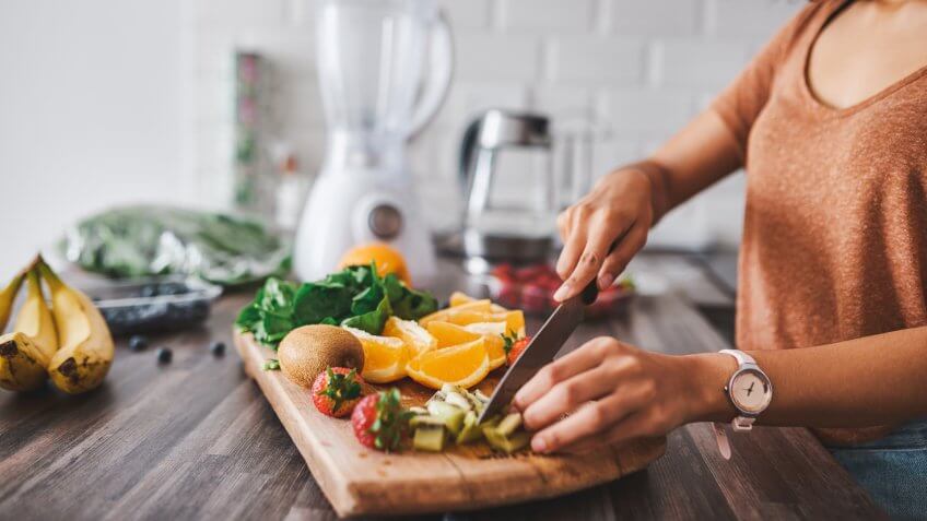Cropped shot of a young woman making a healthy snack with fruit at home.