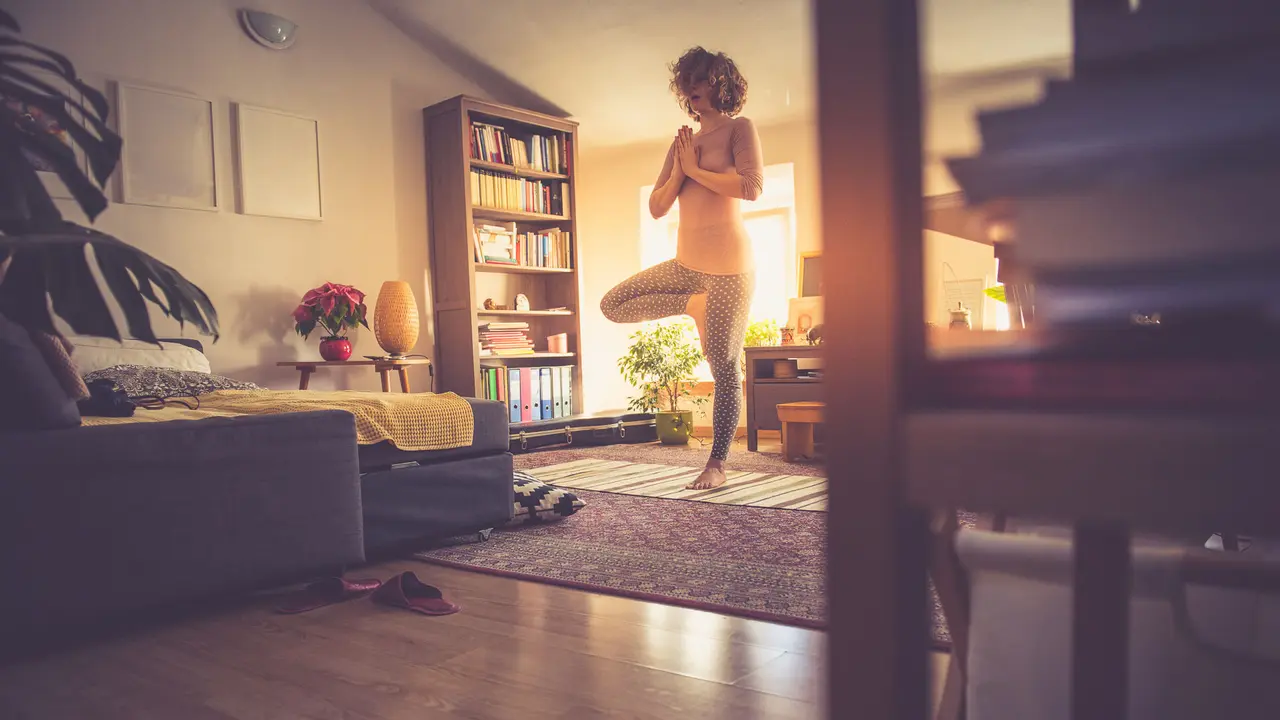 Woman relaxing with yoga at home.