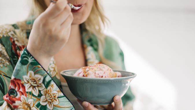 Beautiful pregnant woman eating ice cream.